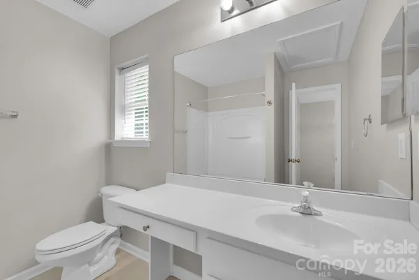 a bathroom with a sink toilet and window