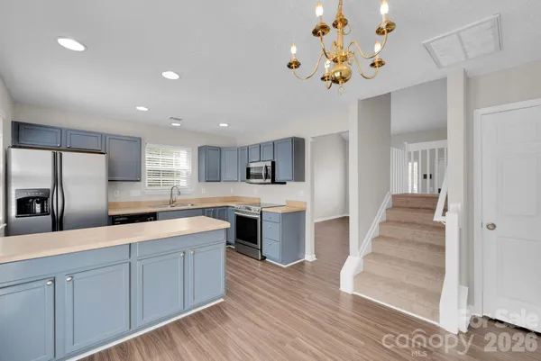 a large kitchen with cabinets and wooden floor