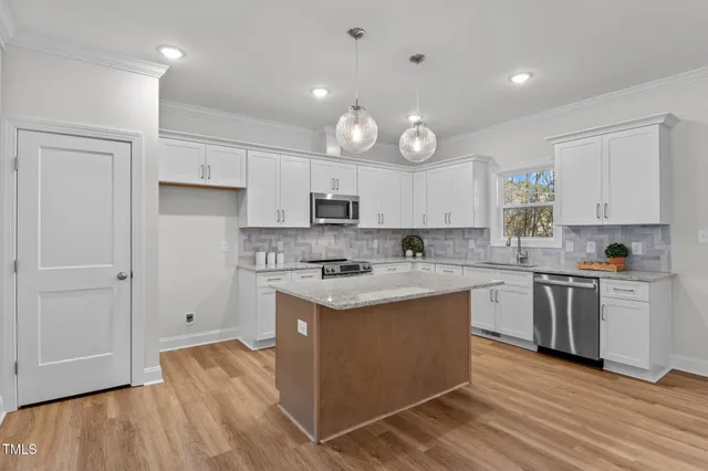a kitchen with granite countertop cabinets stainless steel appliances a sink and a counter space
