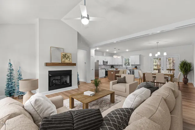 a large white kitchen with kitchen island a sink a center island stainless steel appliances and a fireplace