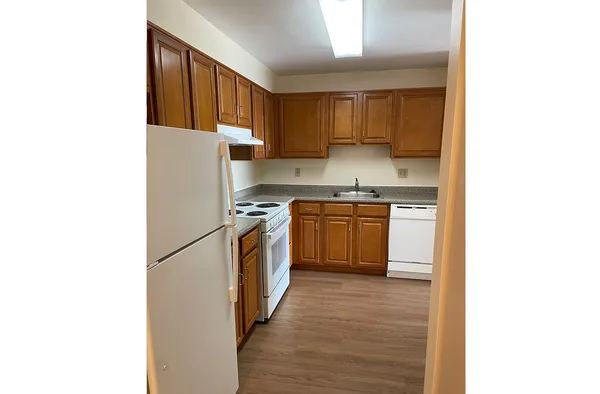 a kitchen with a sink a refrigerator and cabinets