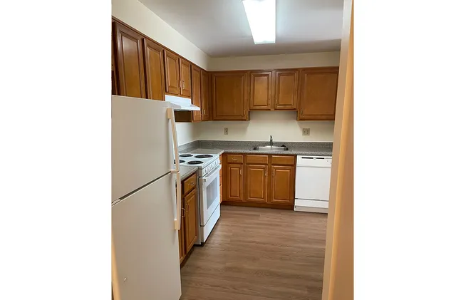 a kitchen with a sink a refrigerator and cabinets