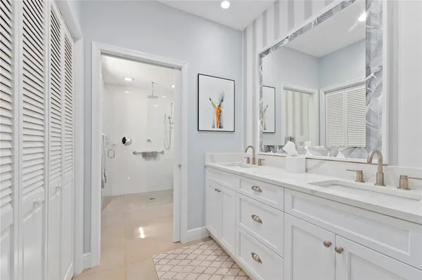 a bathroom with a double vanity sink a mirror and shower