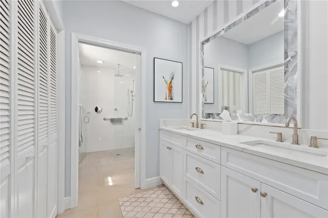 a bathroom with a double vanity sink a mirror and shower