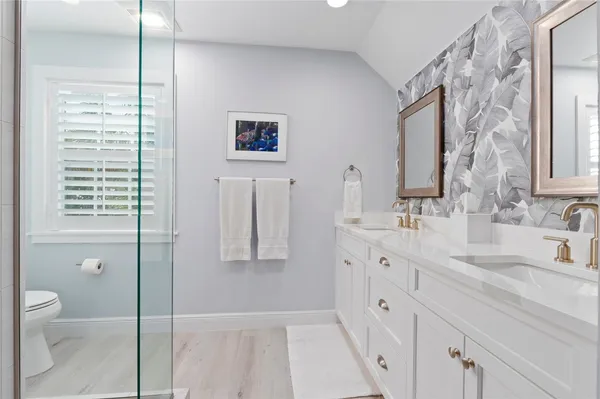 a spacious bathroom with double vanity a toilet a and a sink