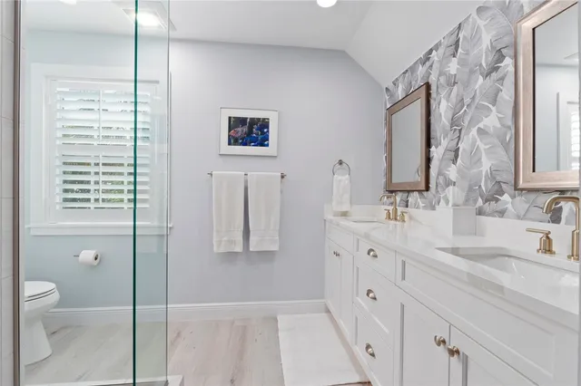 a spacious bathroom with double vanity a toilet a and a sink
