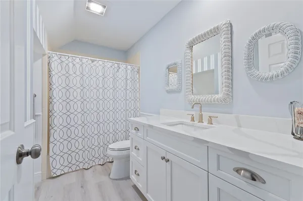 a bathroom with a sink a toilet and a mirror