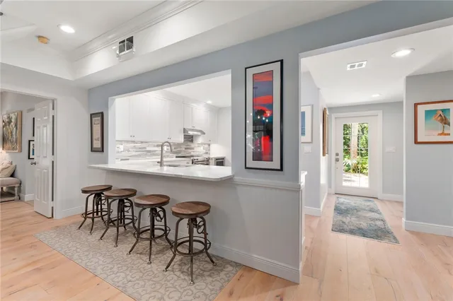 a kitchen with stainless steel appliances granite countertop a table and chairs in it