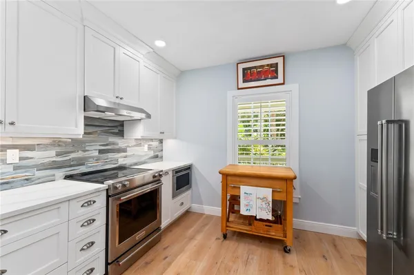 a kitchen with granite countertop a stove a sink and a refrigerator