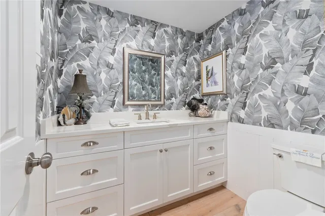 a bathroom with a sink vanity granite and toilet