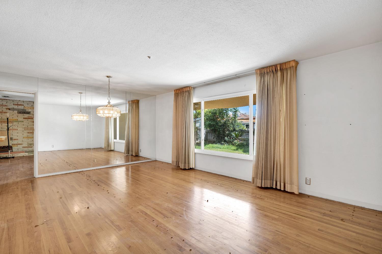 3376 East Richert Avenue Fresno, CA 93726 - Photo 17 of 29 an empty room with wooden floor and windows
