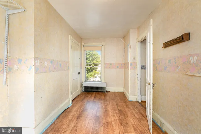 a view of a hallway with wooden floor and a window