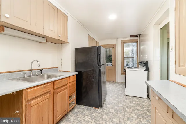 a kitchen with a sink a refrigerator and cabinets