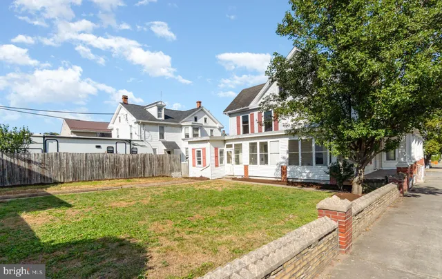 a view of a white house with a yard and plants