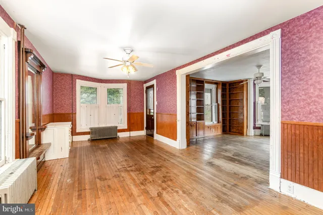 a view of a livingroom with wooden floor and a ceiling fan