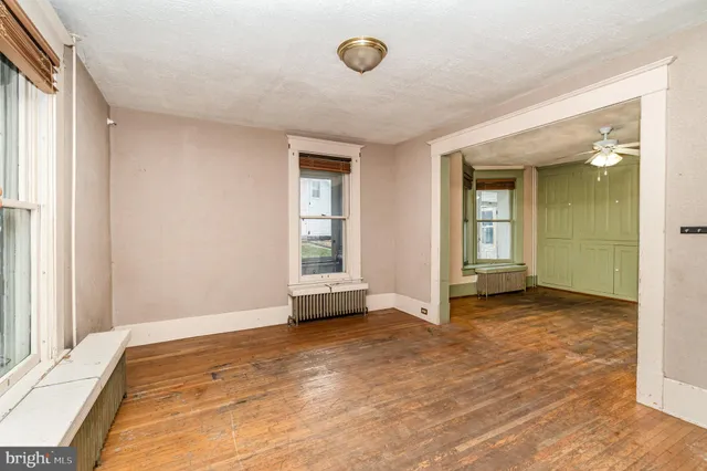 a view of an empty room with window and closet area