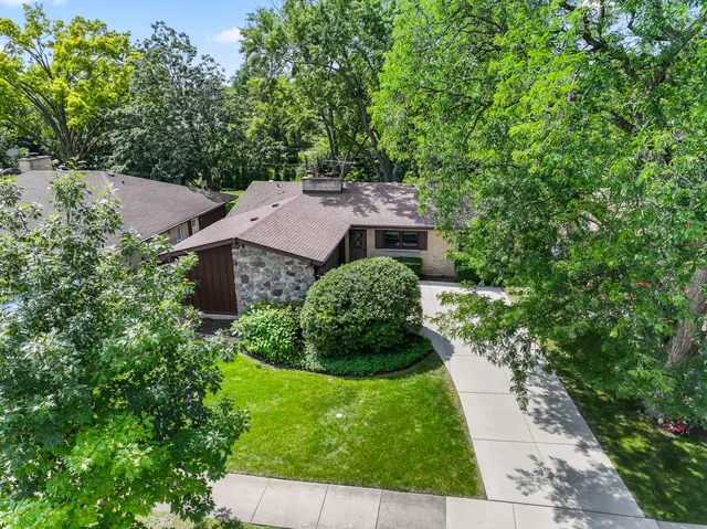 an aerial view of a house with a yard and trees