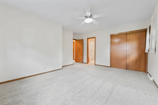 a view of an empty room with chandelier fan