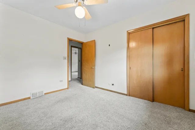 an empty room with a chandelier fan and a chandelier fan