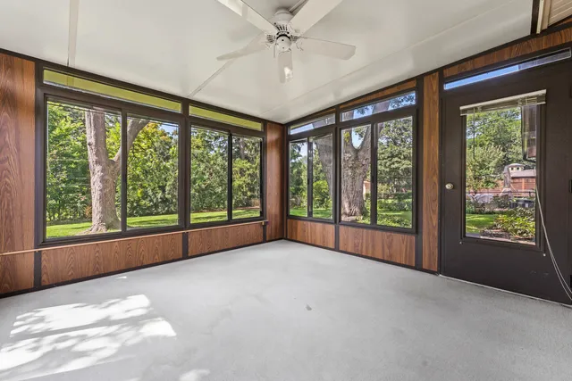 a view of an empty room with windows and chandelier
