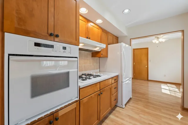 a kitchen with stainless steel appliances granite countertop a stove a refrigerator and a cabinets