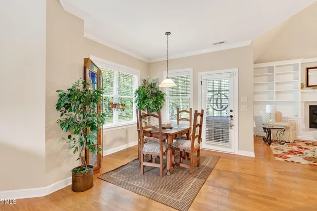 a dining room with furniture potted plants and wooden floor