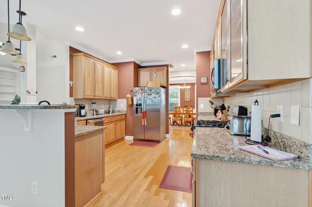 a kitchen with stainless steel appliances granite countertop a sink refrigerator and cabinets