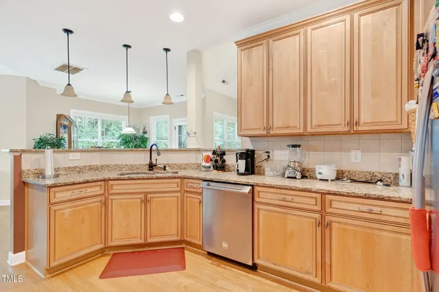 a kitchen with stainless steel appliances granite countertop a sink a stove and cabinets