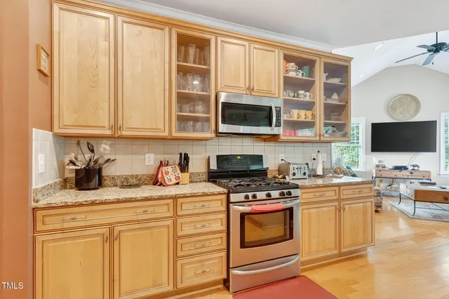 a kitchen with stainless steel appliances granite countertop a stove a sink and a microwave