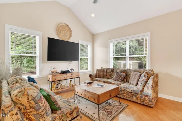 a living room with furniture a flat screen tv and a large window