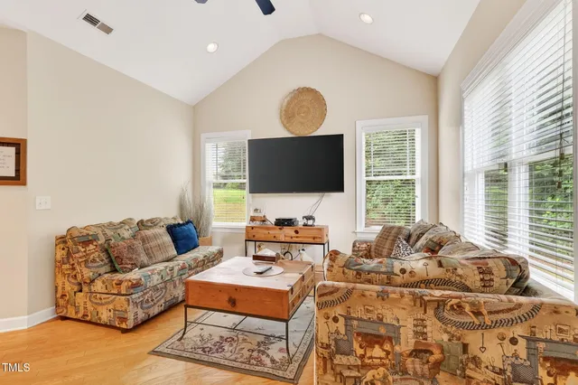 a living room with furniture flat screen tv and a large window