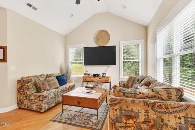 a living room with furniture flat screen tv and a large window