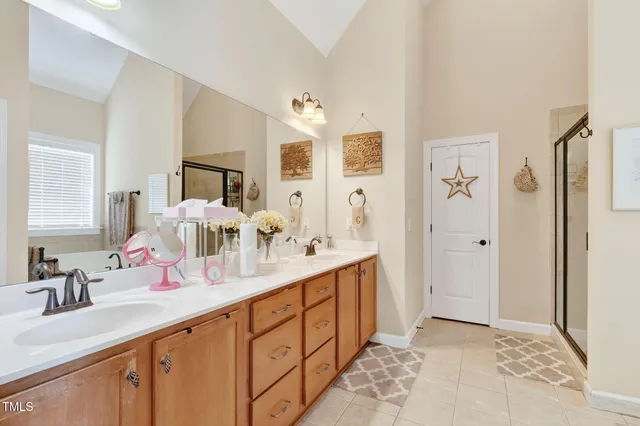 a bathroom with double vanity sinks a vanity two mirror and shower