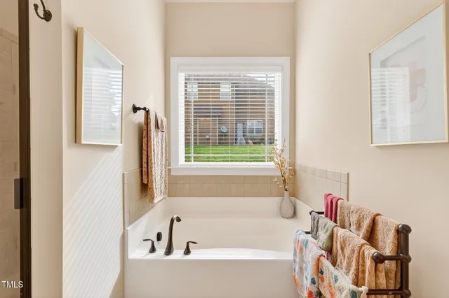 a bathroom with bathtub and window