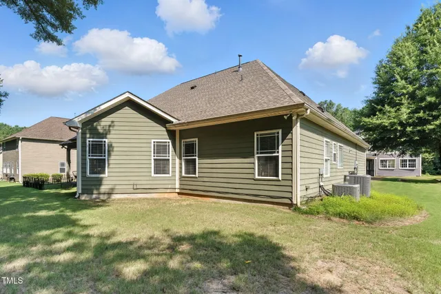 a backyard of a house with yard table and chairs