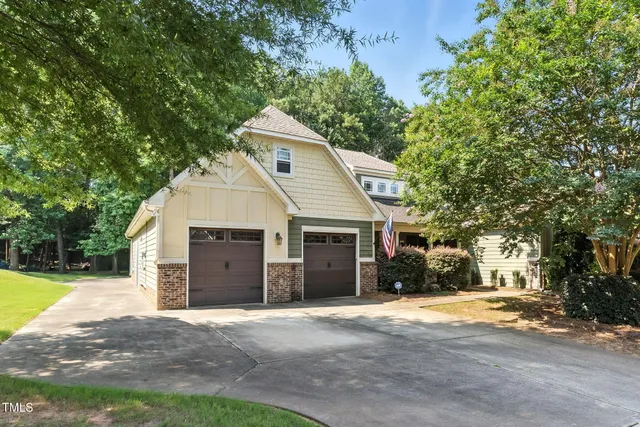 a view of a house with a yard and large tree