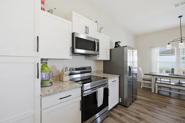 a kitchen with stainless steel appliances a stove microwave and refrigerator