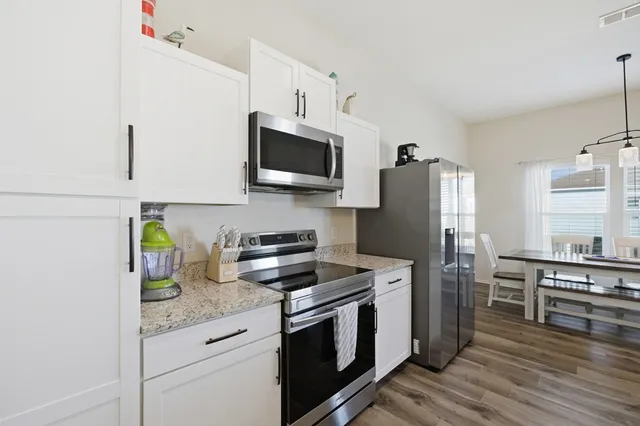 a kitchen with stainless steel appliances a stove microwave and refrigerator