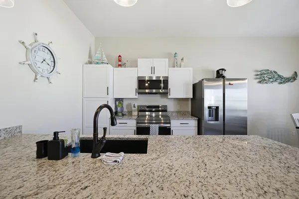 a kitchen with stainless steel appliances kitchen island a refrigerator sink and cabinets