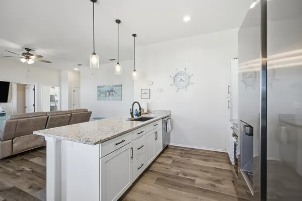 a bathroom with a granite countertop sink a toilet a large mirror and shower