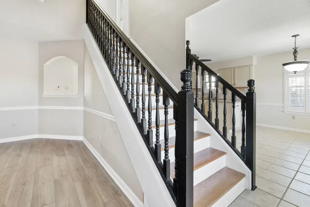 a view of staircase with wooden floor and white walls