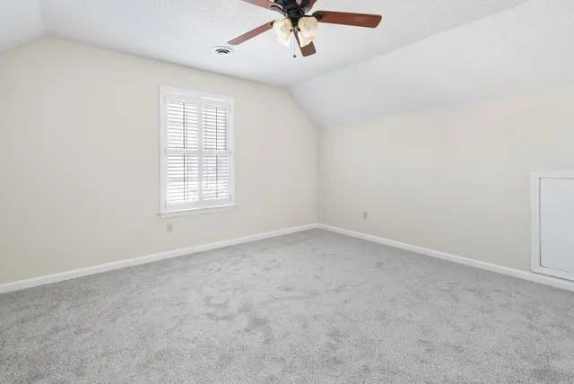 an empty room with a window and a ceiling fan