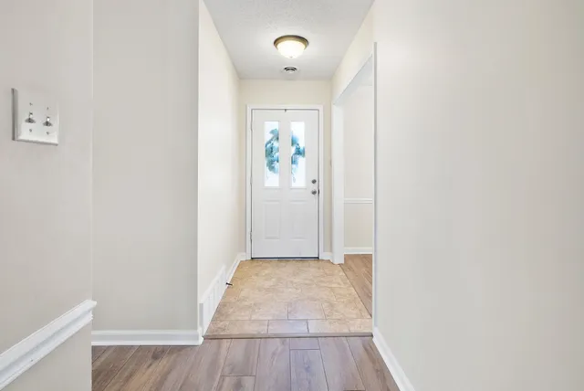 a view of a hallway with wooden floor