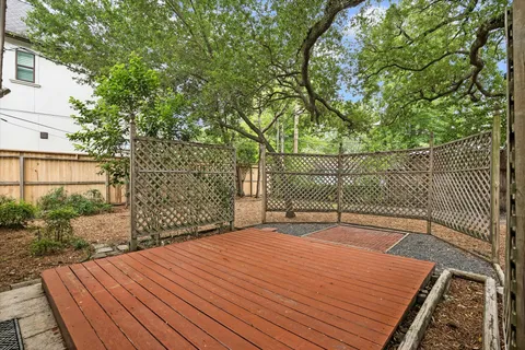 a backyard with wooden fence and large trees