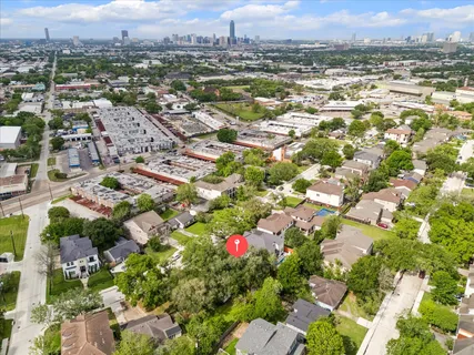 an aerial view of residential houses with outdoor space and trees