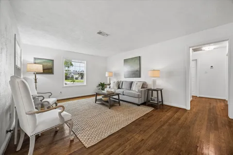 a living room with furniture and a wooden floor