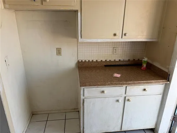 a view of kitchen with granite countertop white cabinets and white appliances
