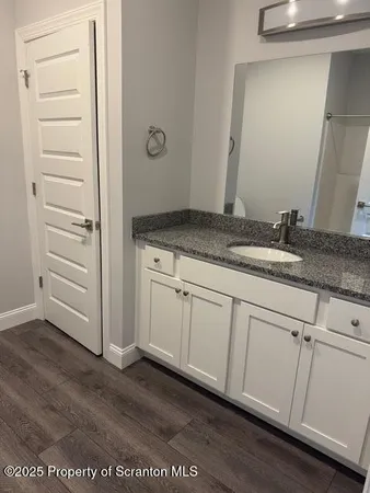 a bathroom with a granite countertop sink and mirror
