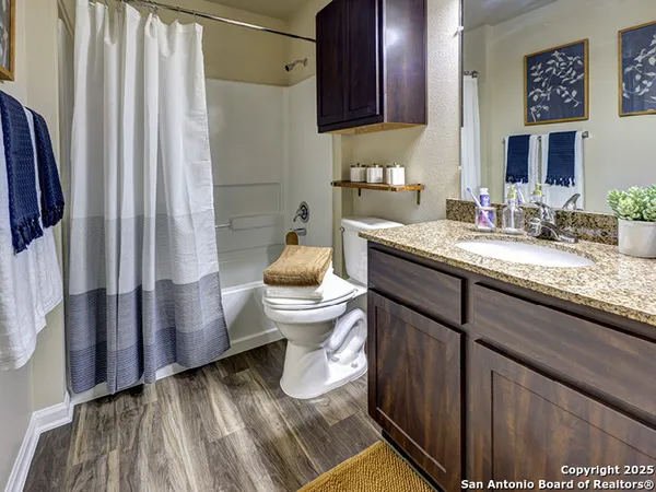 a bathroom with a granite countertop sink toilet and shower