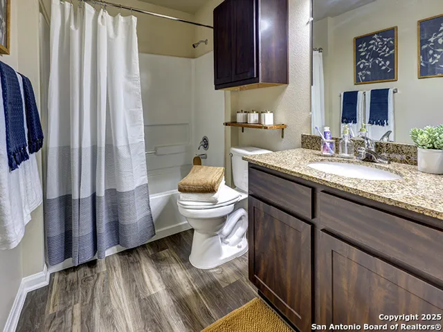 a bathroom with a granite countertop sink toilet and shower